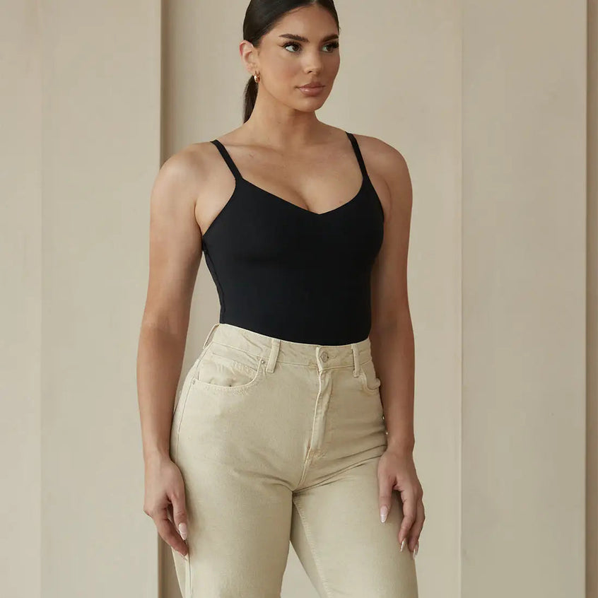 Woman wearing a Skimmylo Snatched Shapewear Bodysuit and beige pants against a neutral background